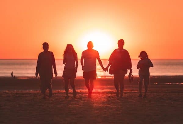 Family in dependence on beach at sunset