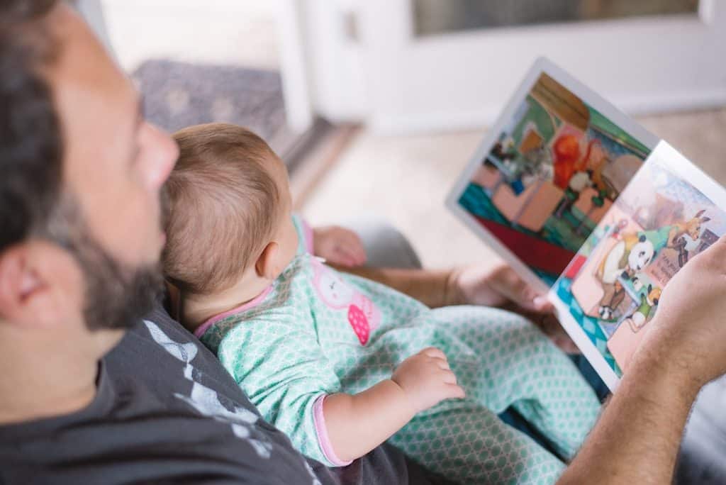 Father living with infant and reading together