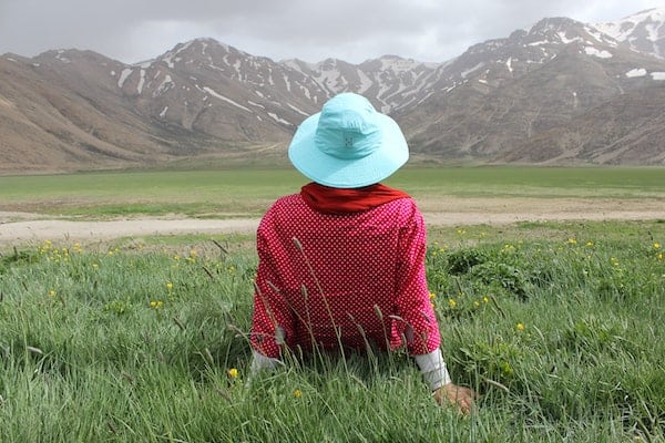 Relax - Woman relaxing in meadow admiring mountains