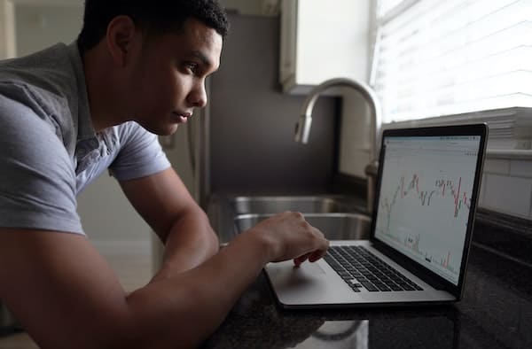 Young man checking his investment returns at home