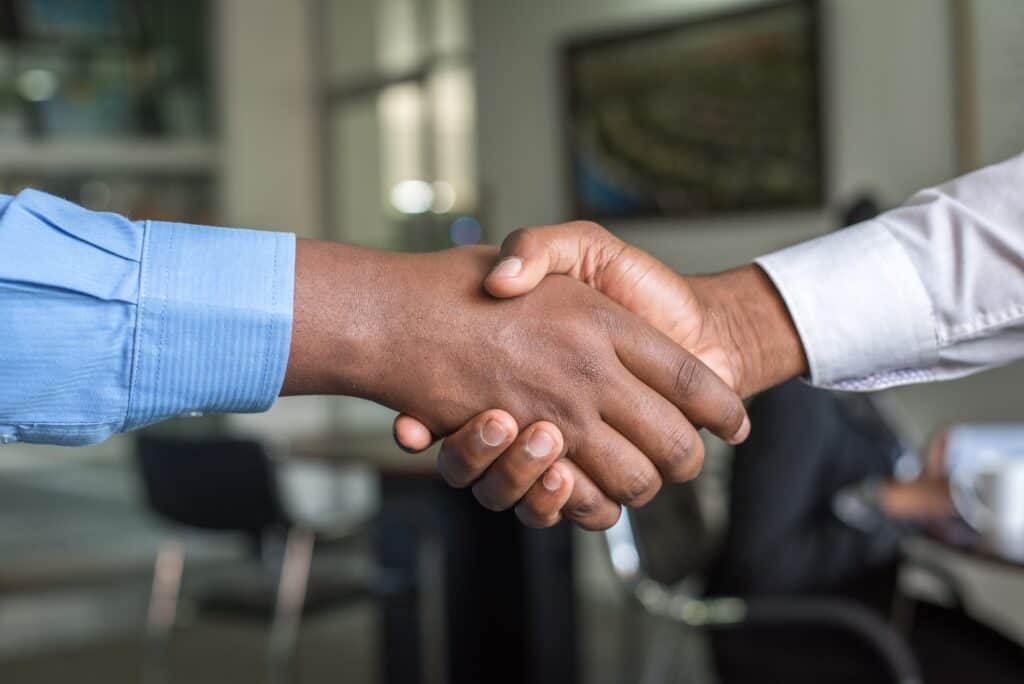 Two hands extended in a handshake.