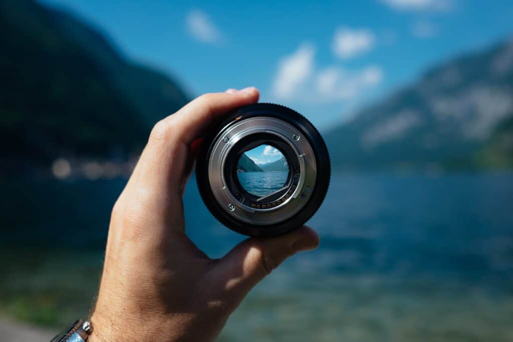 A hand holding up a lens to make a clear image.