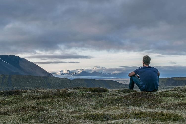 man contemplating staring out over mountains