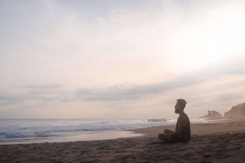 man sitting on the beach enjoying the silence
