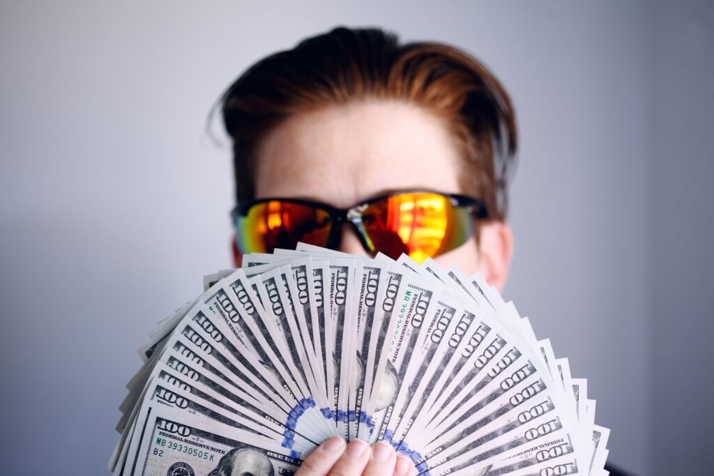 man in sunglasses holding money