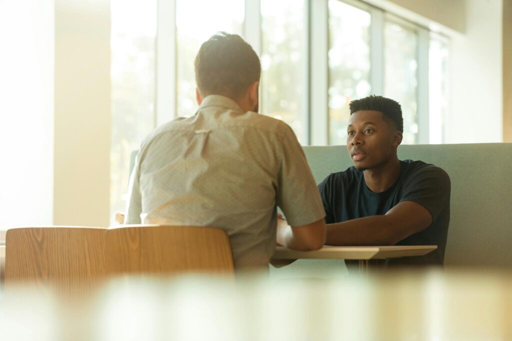 Two people sitting at a table having a discussion