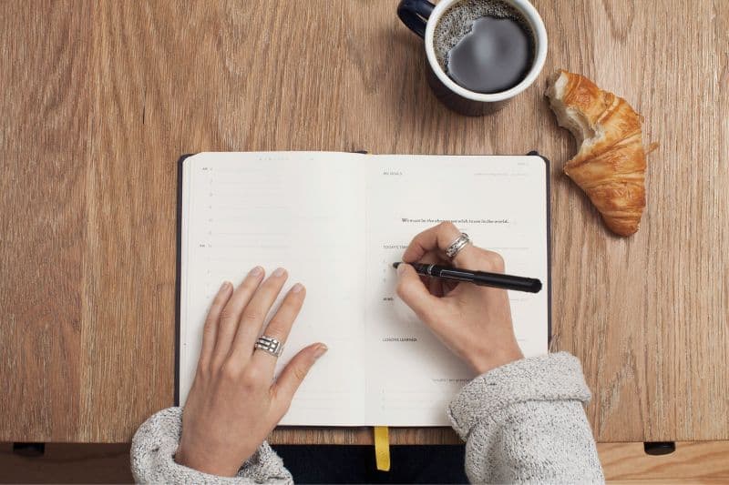 Person writing in book