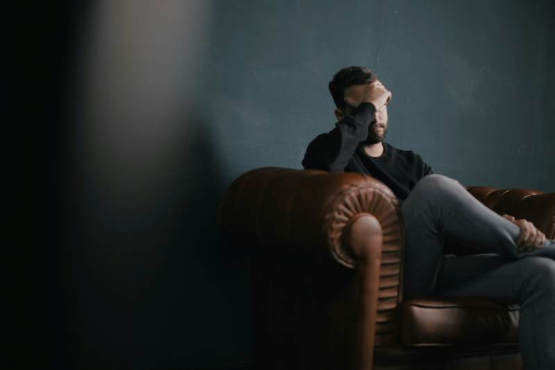 A man sitting on the couch upset